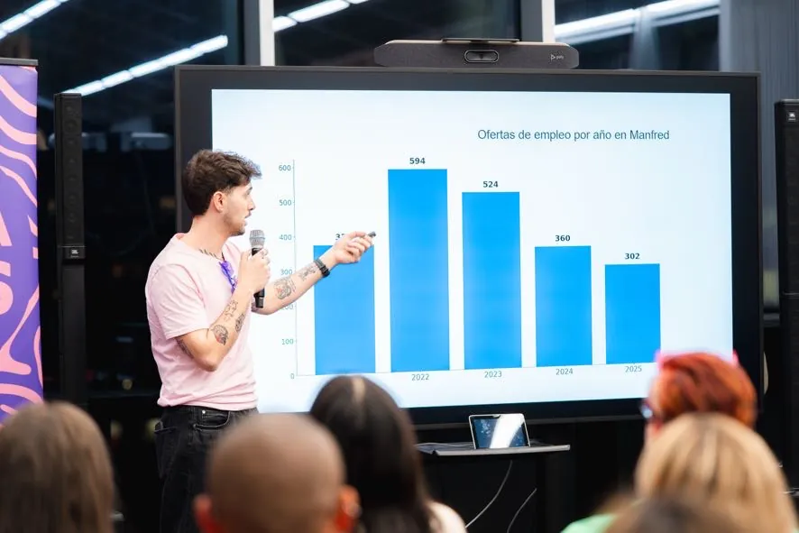 Ponente presentando una gráfica en el escenario durante un evento de Arcasiles