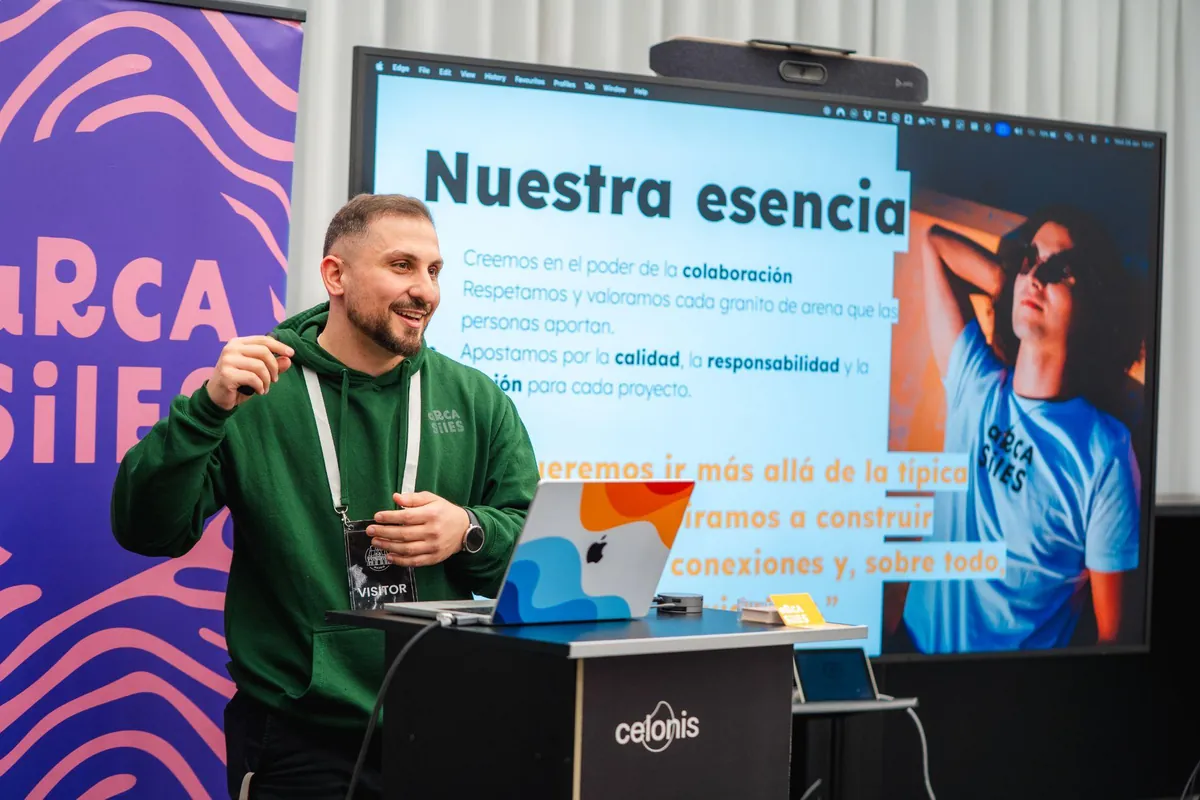 Ponente en el atril con la pantalla «Nuestra esencia» proyectada de fondo